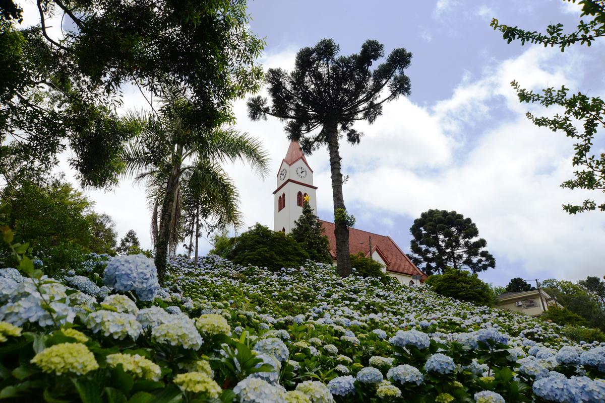 "Vista aérea do novo aeroporto Serra Gaúcha, mostrando suas modernas instalações e pistas, com as montanhas ao fundo"